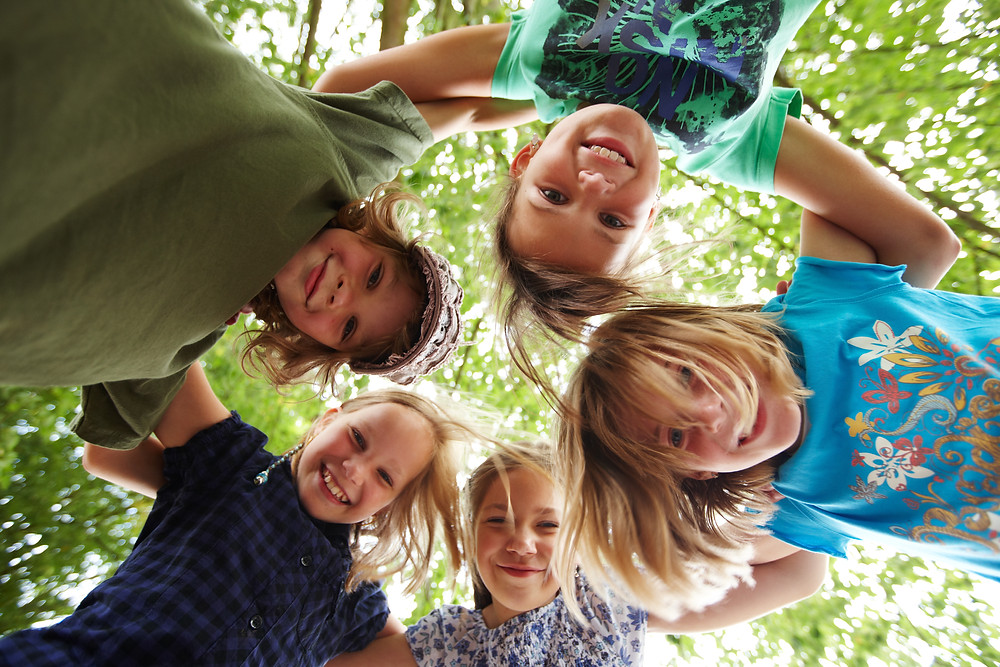 Kinder umarmen und schauen zu boden. Spielgruppe