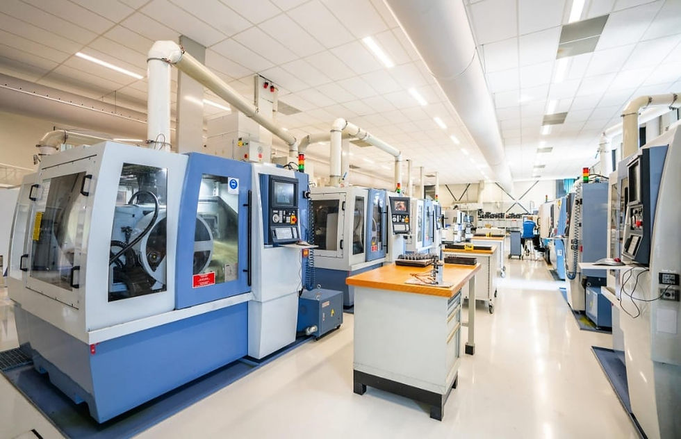 Row of industrial CNC machines in a modern factory facility.