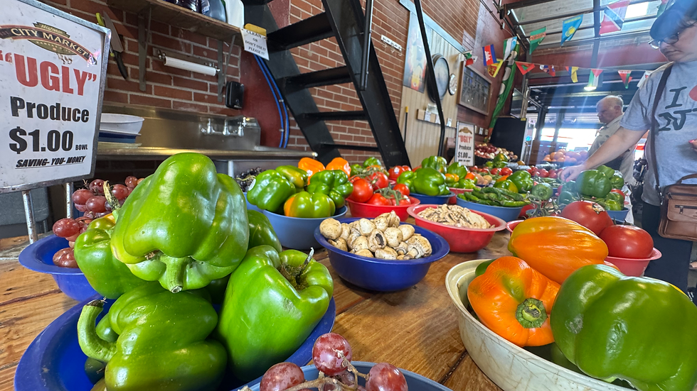Discount "ugly" produce stand with bell peppers, tomatoes, mushrooms, and grapes at City Market in Kansas City, Missouri