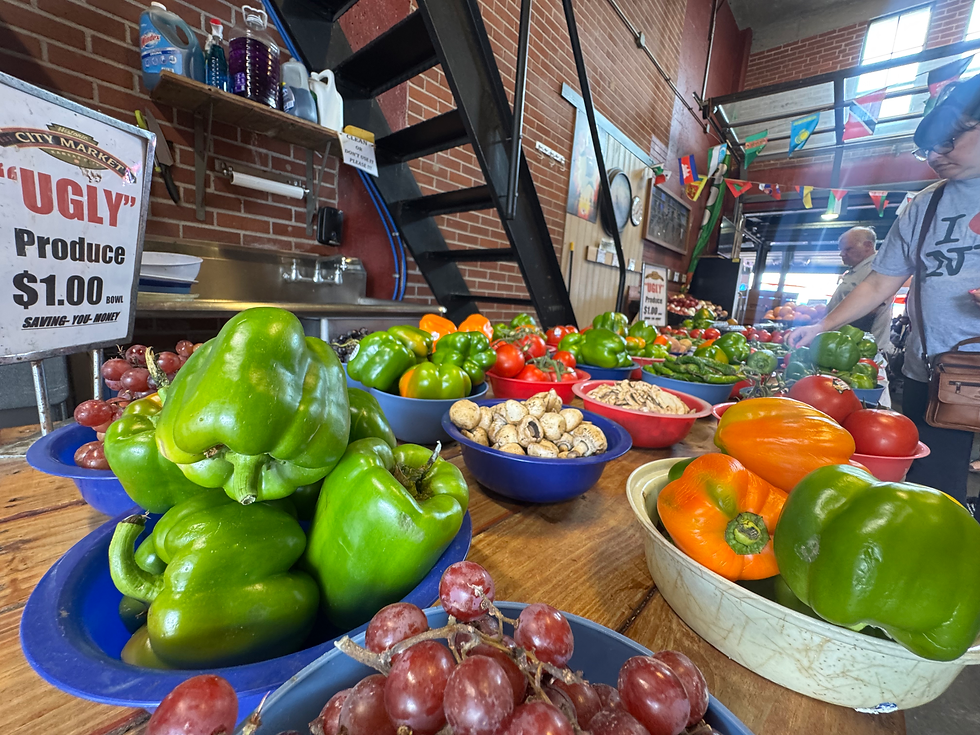 Discount "ugly" produce stand with bell peppers, tomatoes, mushrooms, and grapes at City Market in Kansas City, Missouri