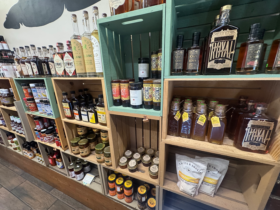 Display of artisan sauces, seasonings, honey, and locally crafted spirits at Local Pig market in Kansas City, Missouri