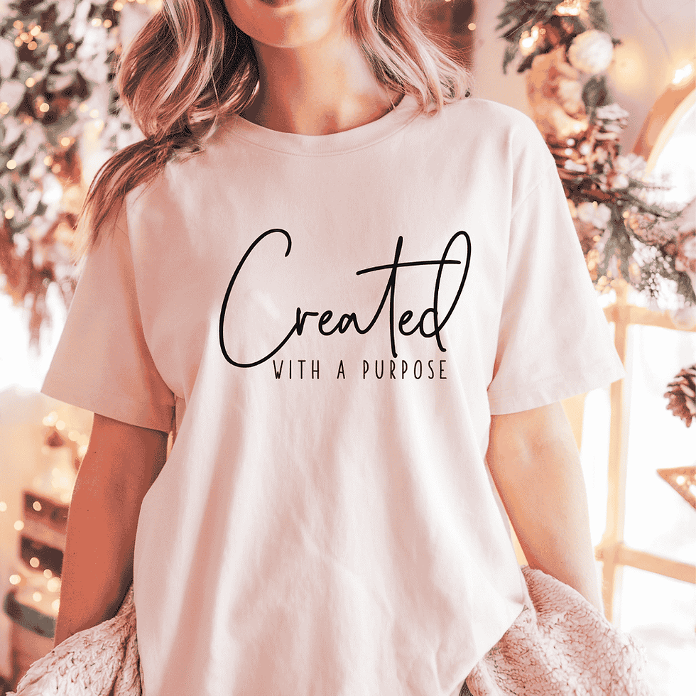 Young girl wearing a white short-sleeve T-shirt with the uplifting phrase 'Created with a Purpose,' promoting self-worth and inspiration.