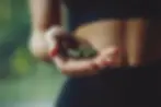 hands-holding-green-capsules-symbolizing-nutrition-fitness-lifestyle copia.webp