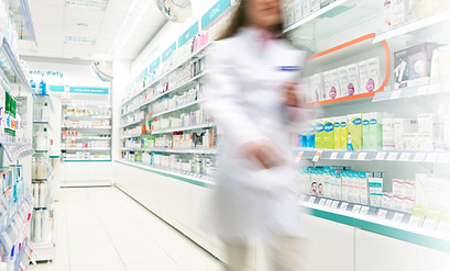 Pharmacist in aisle of Pharmacy