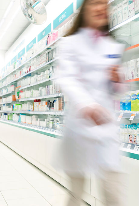 Pharmacist  in aisle of Pharmacy