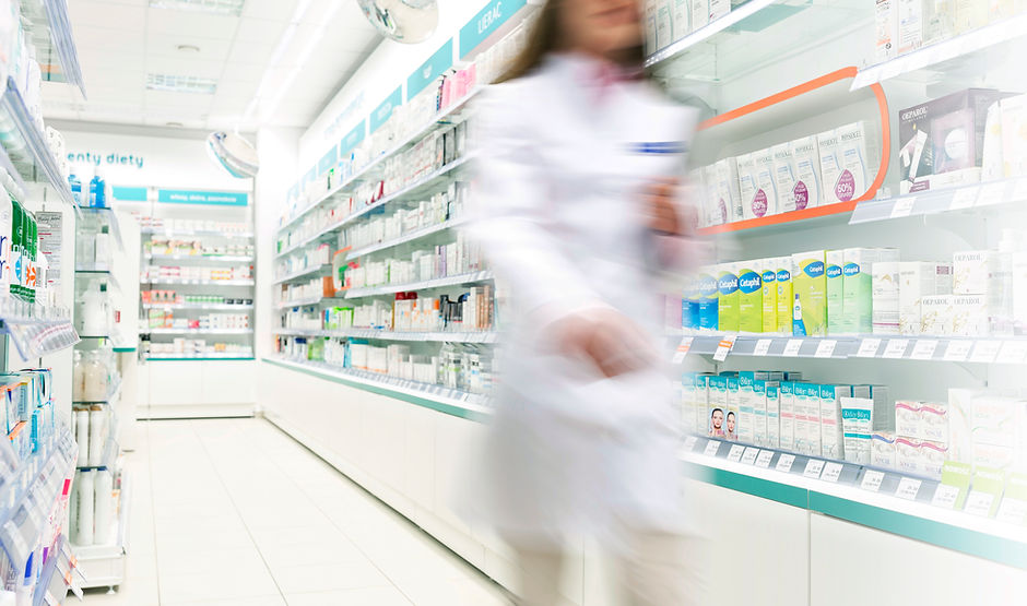 Pharmacist in aisle of Pharmacy