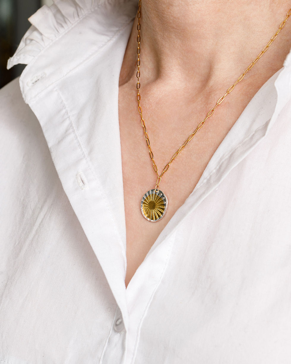 Sunrays Pendant Necklace on a gold chain.