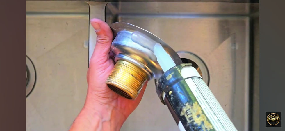 Basket strainer prepared with silicone sealant before installation into a kitchen sink.