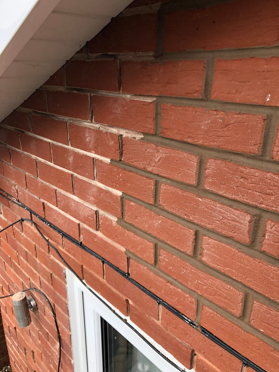 A brick wall being repointed