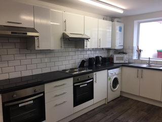 Clean kitchen with white tiles and a grey LVT floor