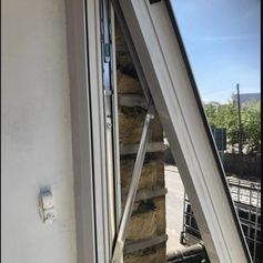A white window that has been repaired with a new hinge.png