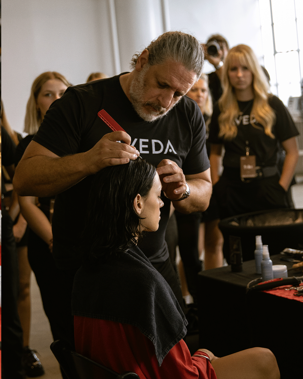 man doing model's hair with comb