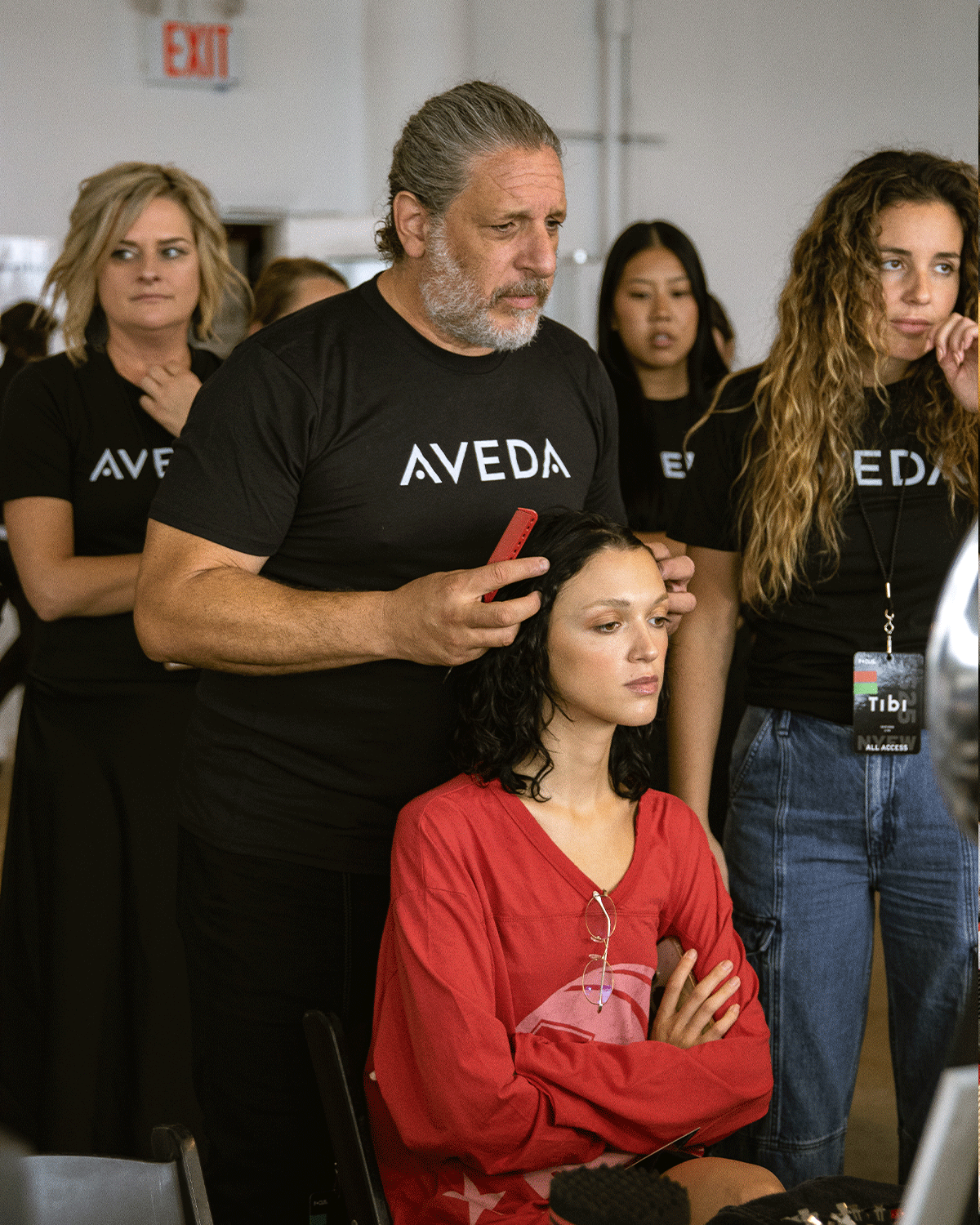 group of people looking at hair tutorial by male hair stylist