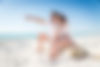 Couple strolling at the beach and smiling - Young adults enjoying summer holidays on a tro