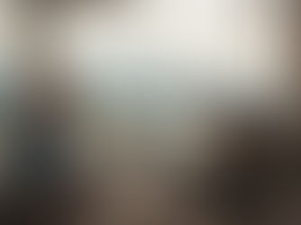 A caregiver sits beside a patient receiving treatment, with a scenic mountain view and medical equipment in a sunlit room.