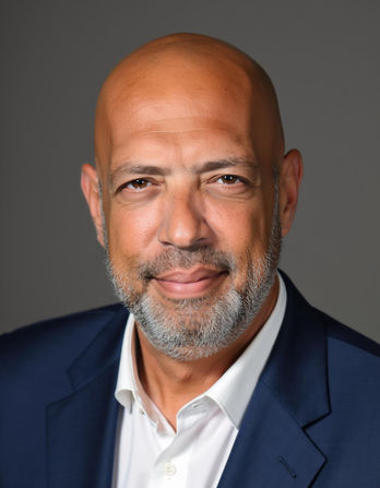 דיוקן של גבר מחייך עם חליפה כחולה על רקע אפור. Smartshot Ai