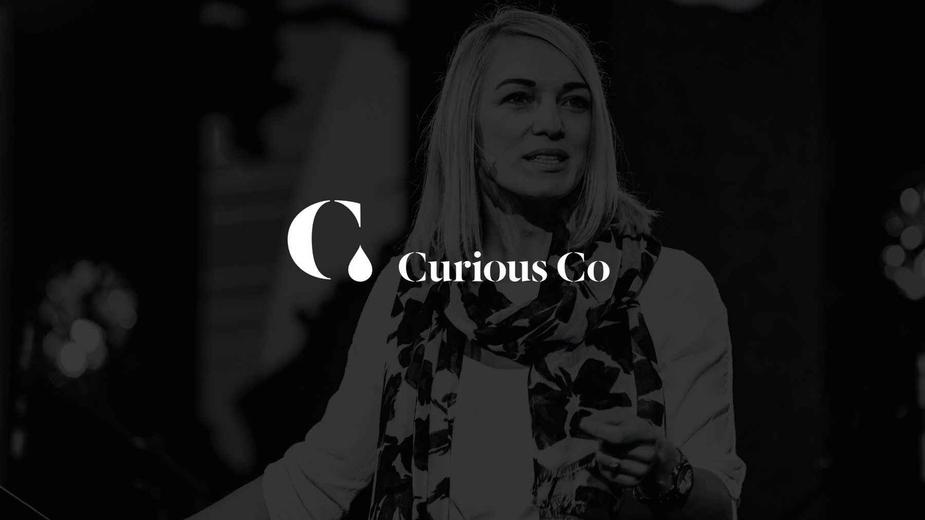The Curious Co logo in white over a black and white portrait