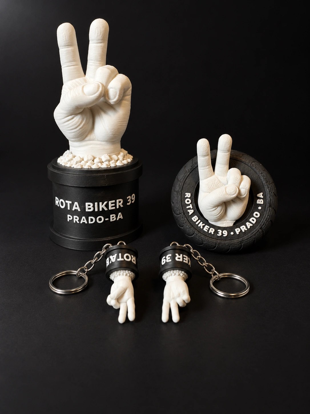 Mini monumento, ímã de pneu e chaveiros Rota Biker 39 fotografados juntos