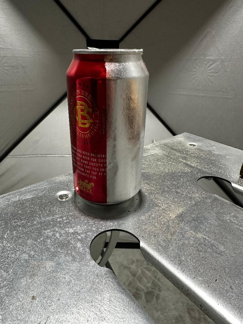 Partially cleaned aluminum can showcasing surface stripping