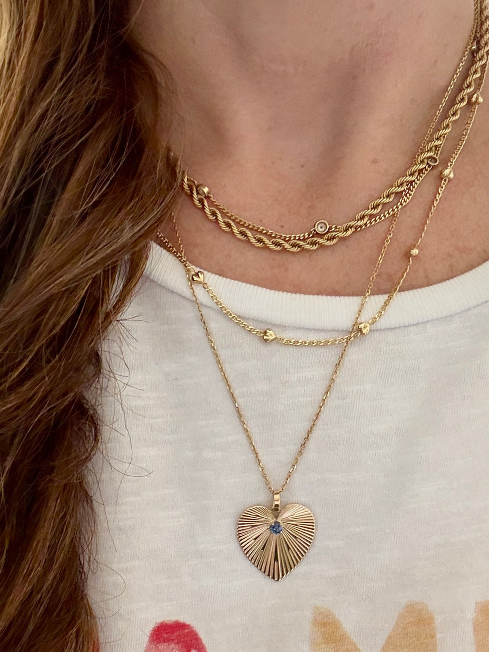 Vintage 14k gold engine-turned heart pendant with a vivid blue sapphire center stone, converted from an original vintage clip