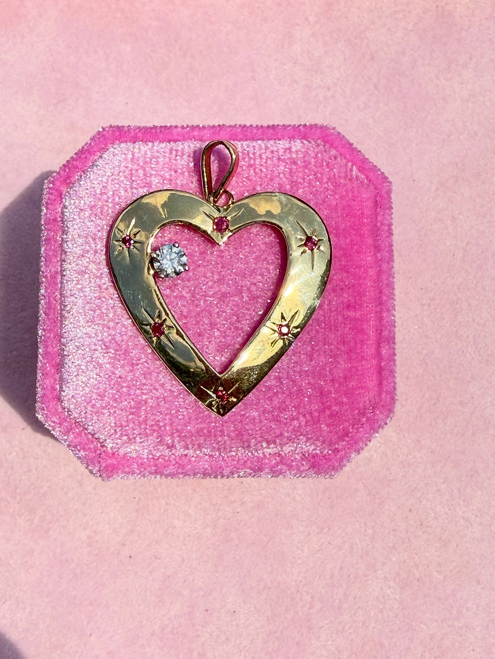 Vintage 14k ruby and floating diamond heart pendant photographed on pink velvet box