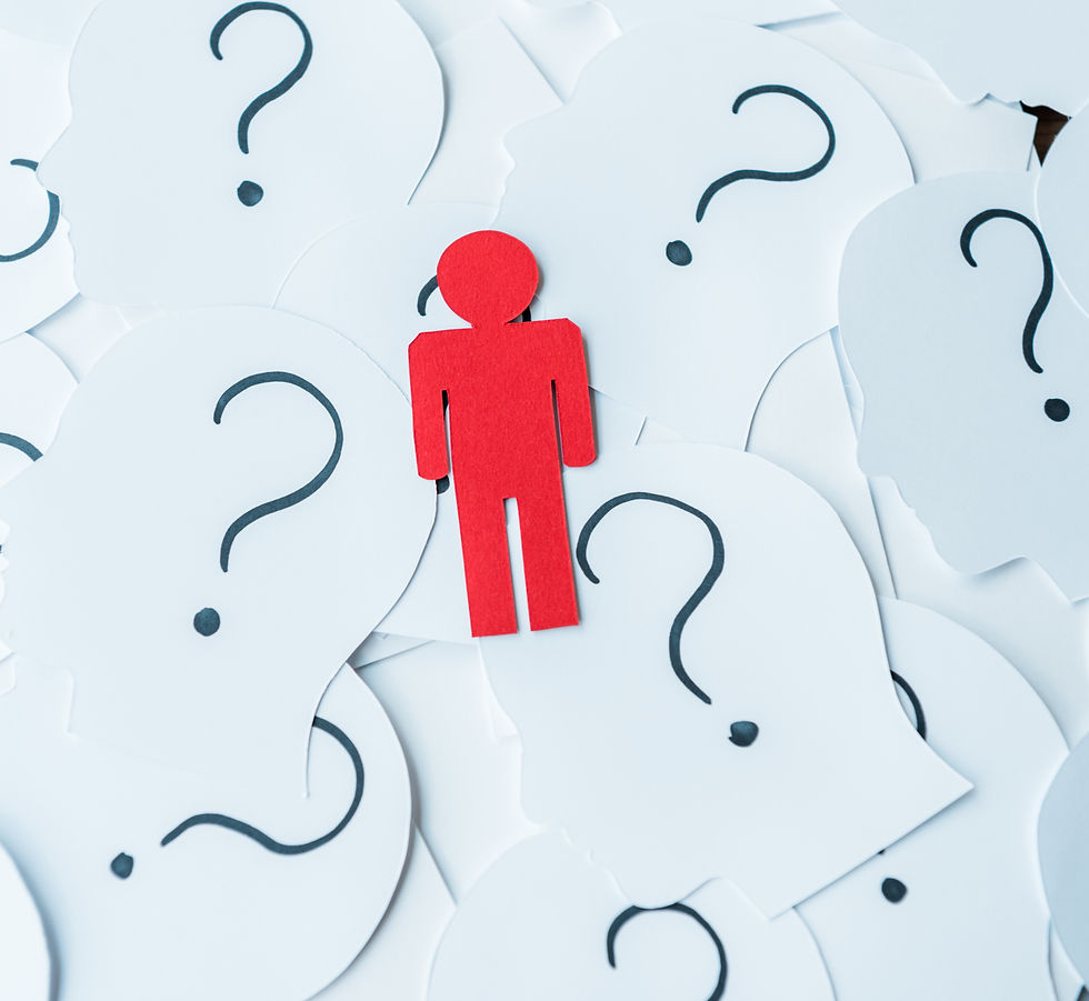 White paper cutouts shaped like human heads, each marked with a question mark, surrounding a single red figure that stands out from the group.