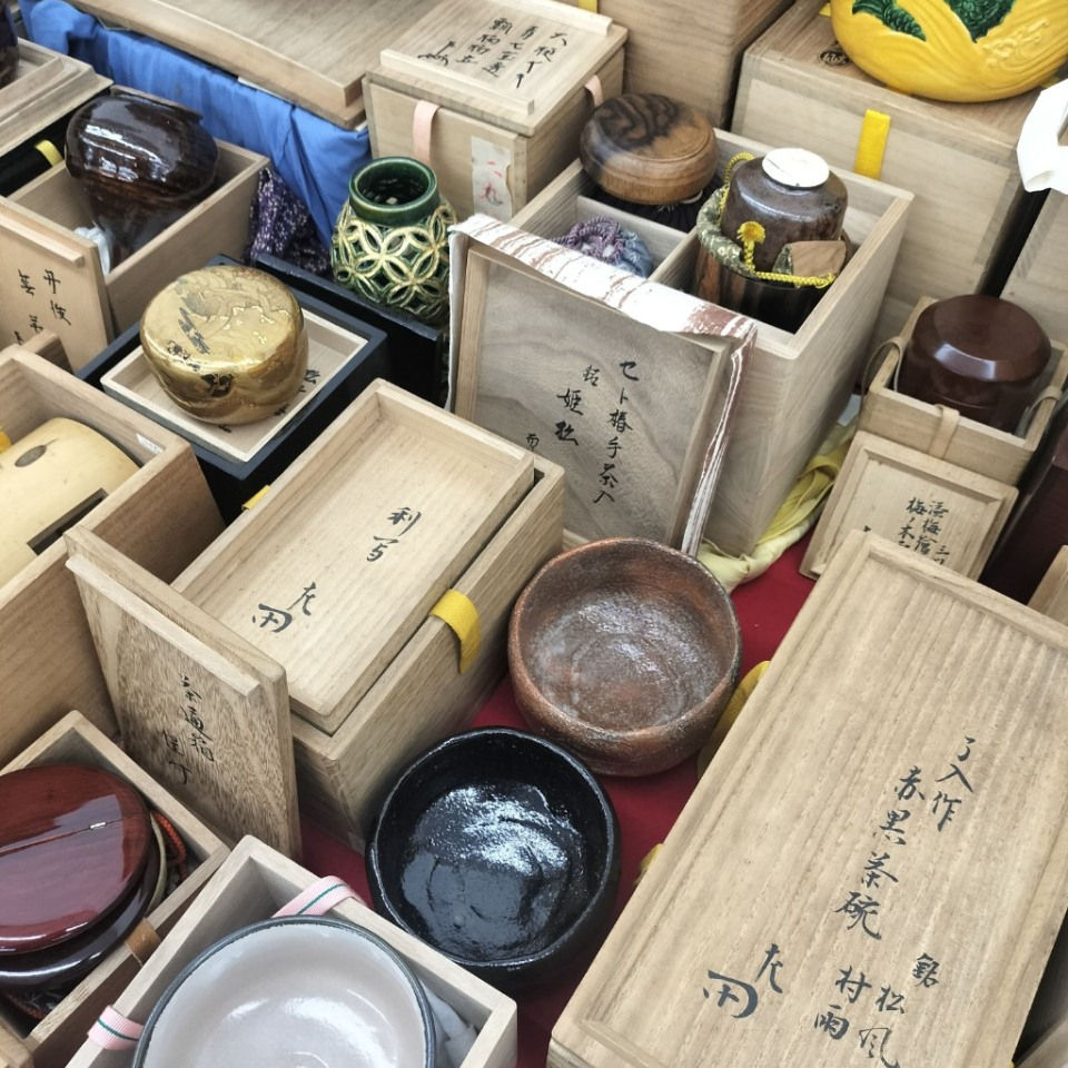 茶道のお点前の配置。畳の上に置かれた黒真塗の風炉釜(ふろがま)、その左側に水指(みずさし)、手前に黒楽茶碗と茶入、初音模様の蒔絵の棗、茶筅、茶杓が美しく並ぶ様子