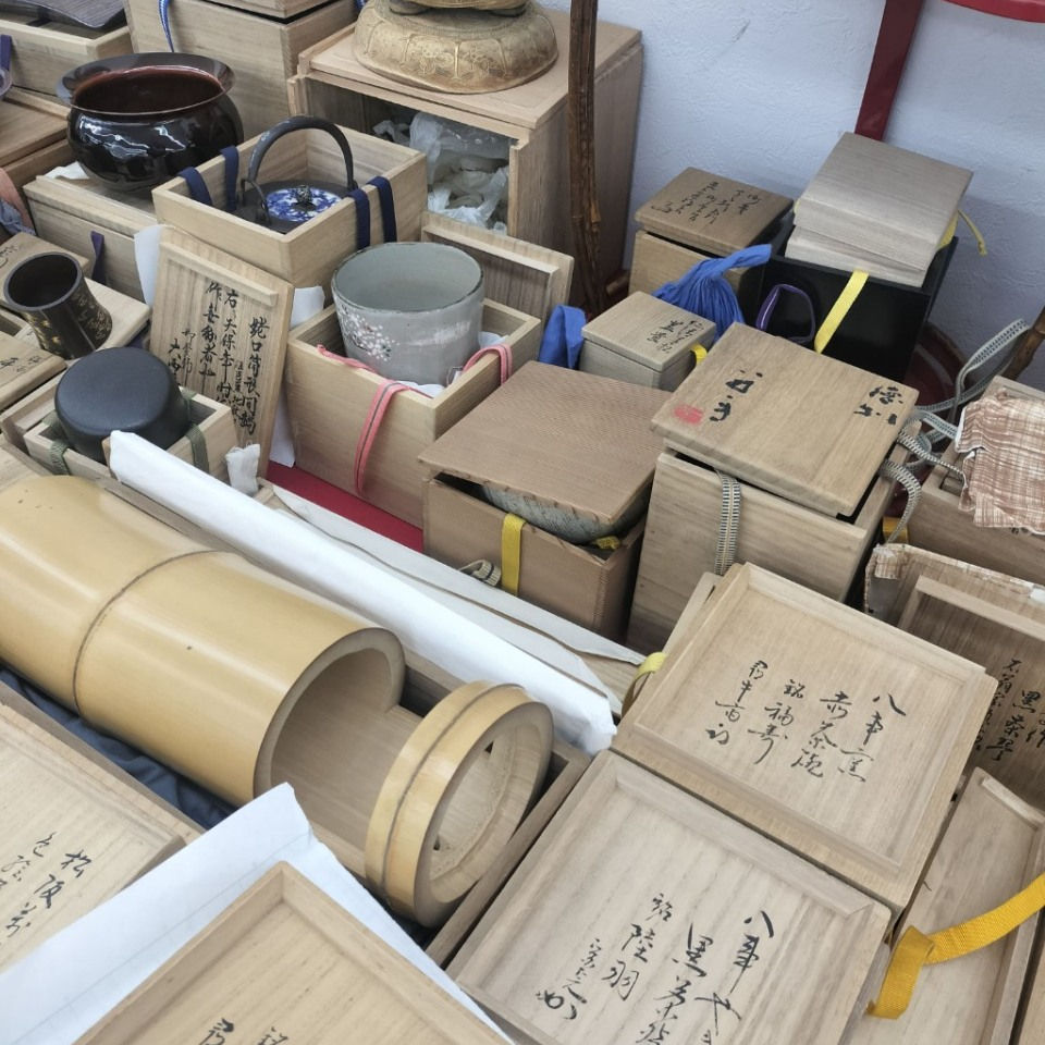 茶道のお点前の配置。畳の上に置かれた黒真塗の風炉釜(ふろがま)、その左側に水指(みずさし)、手前に黒楽茶碗と茶入、初音模様の蒔絵の棗、茶筅、茶杓が美しく並ぶ様子
