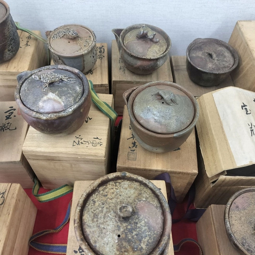 備前焼の買取査定での備前焼の鑑定風景。鑑定士が作品の底面にある名工のサインや、共箱の筆跡を確認して丁寧に査定している様子
