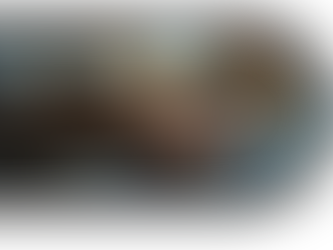 Hands are typing on a dark laptop keyboard. The background is blurred with warm tones, creating a focused and busy atmosphere.