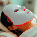 _Woman Getting Red Light Therapy for her Skin with Mask. Lady using professional services 