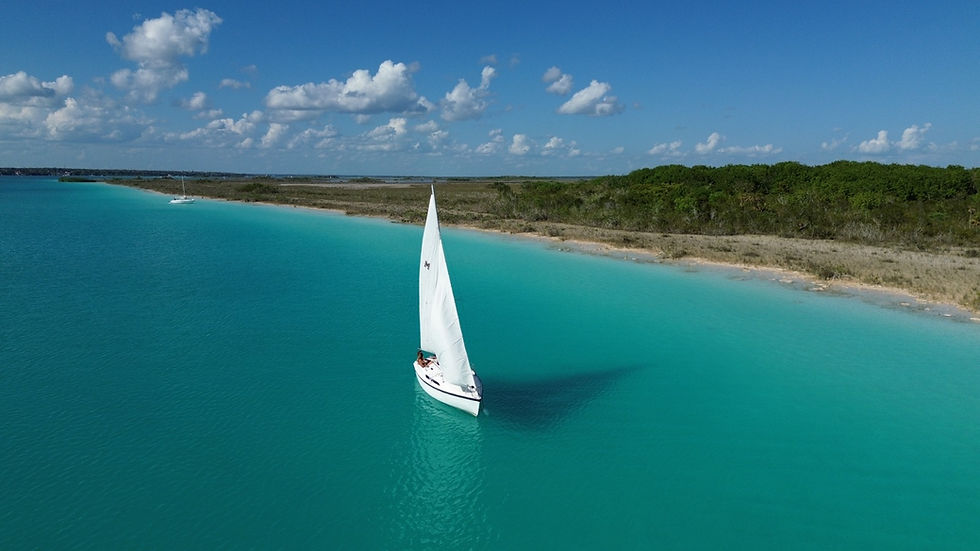 Vista aérea de la Laguna de Bacalar con velero navegando
