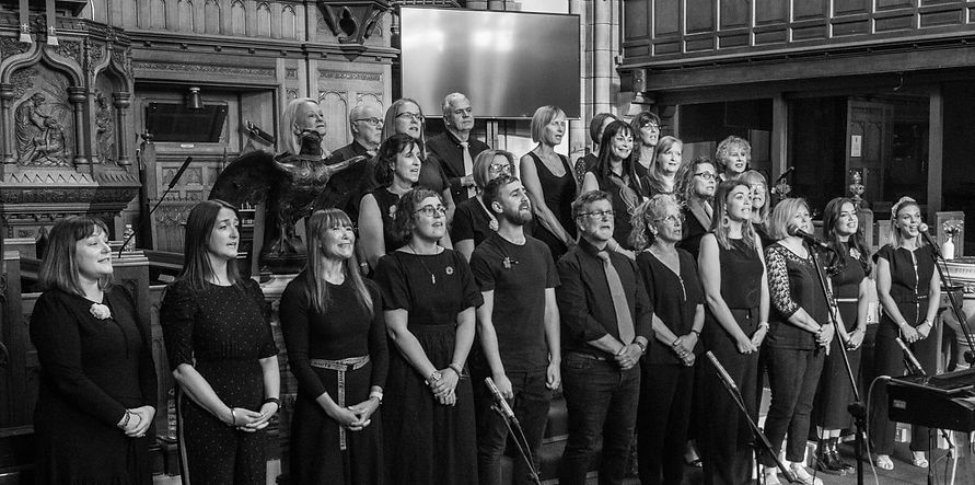 Singers from The Upbeats choir performing during a charity concert