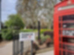 A traditional red telephone box next to the entrance of paddington green in the city of westminster, london.