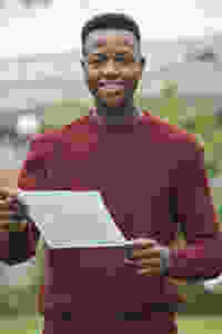 Teenage oy holding A level and GCSE results on Results day 2020