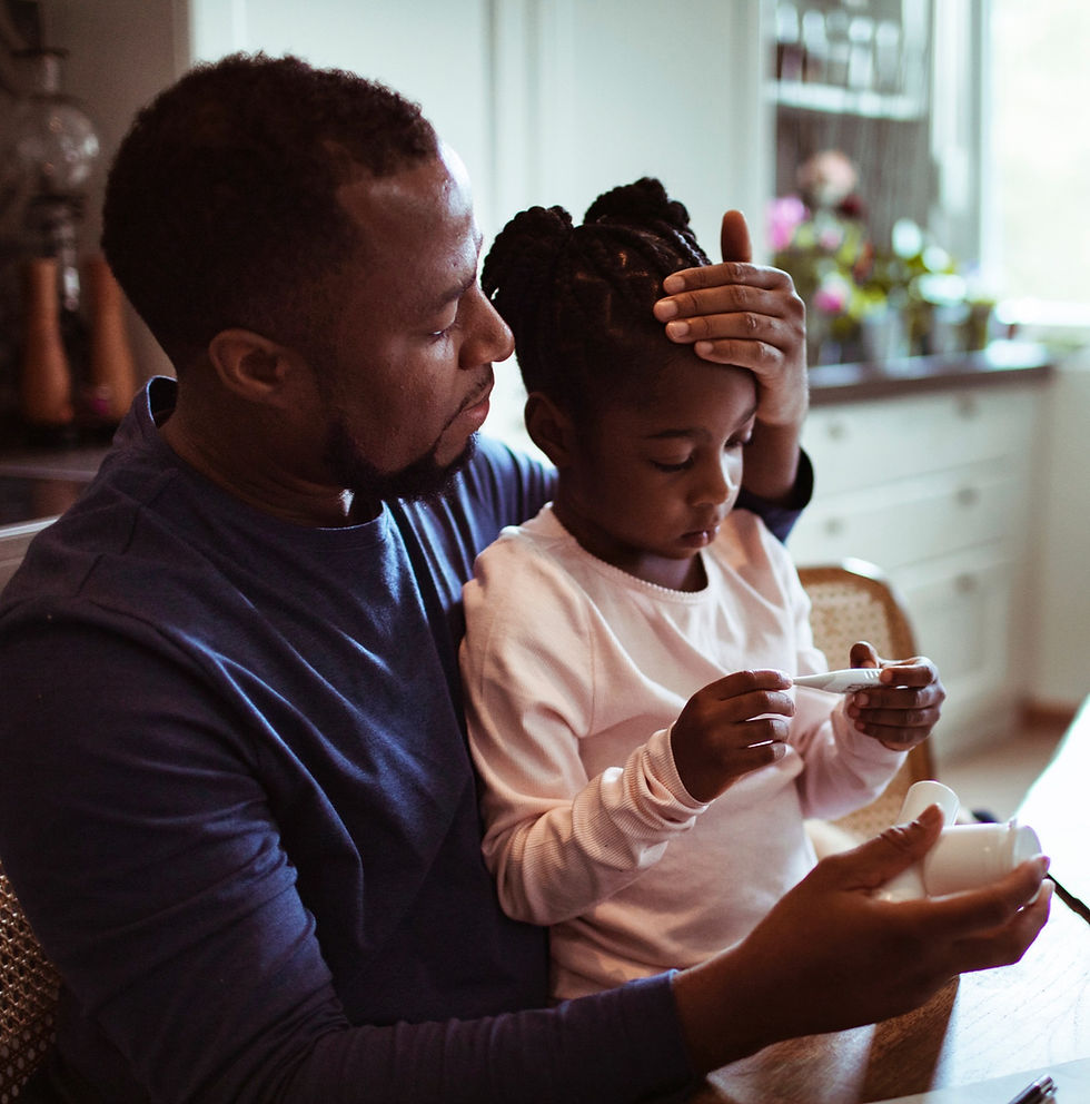 Father checking his daughter's temperature in the kitchen