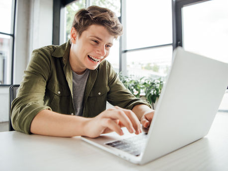 A teenager using a laptop safely