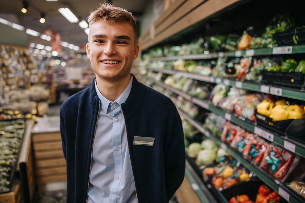 Male teenager working at a supermarket part time during studies