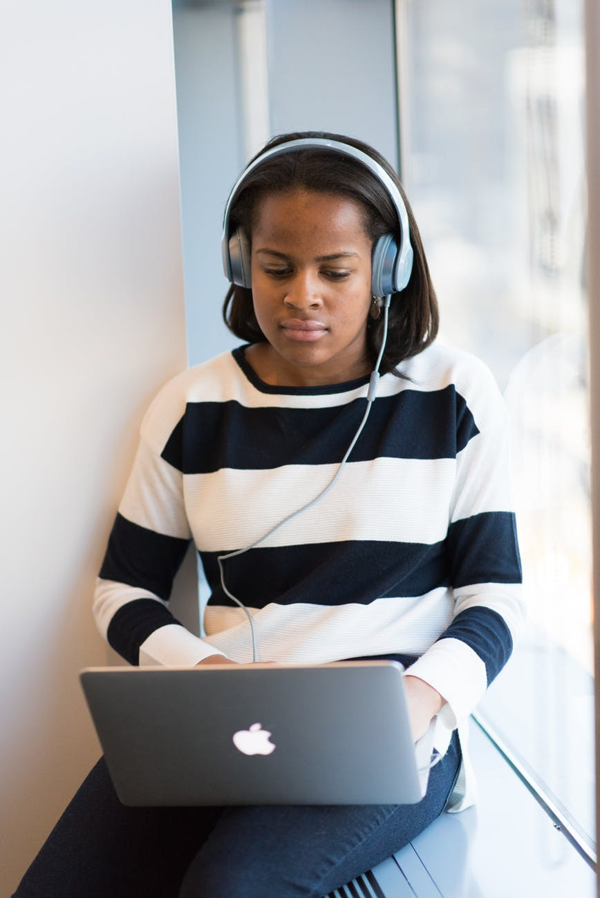 Femal teen student sitting and listening to a podcast with headphones and a laptop The Parents' Guide to helping your child stand out from the crowd