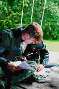 Two teenage boys outside looking at map and studying together