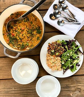 Pot of kale lentil soup and salad on a plate