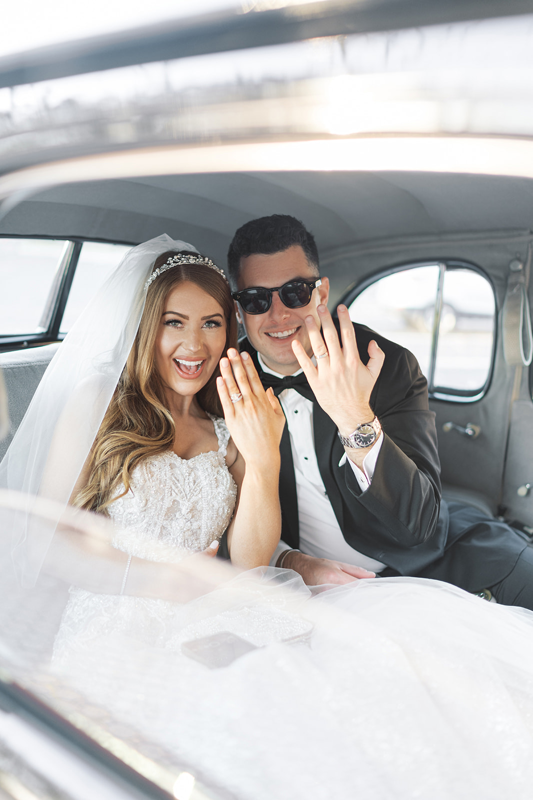 Dom and Hayley laughing together inside the vintage wedding car in Cincinnati