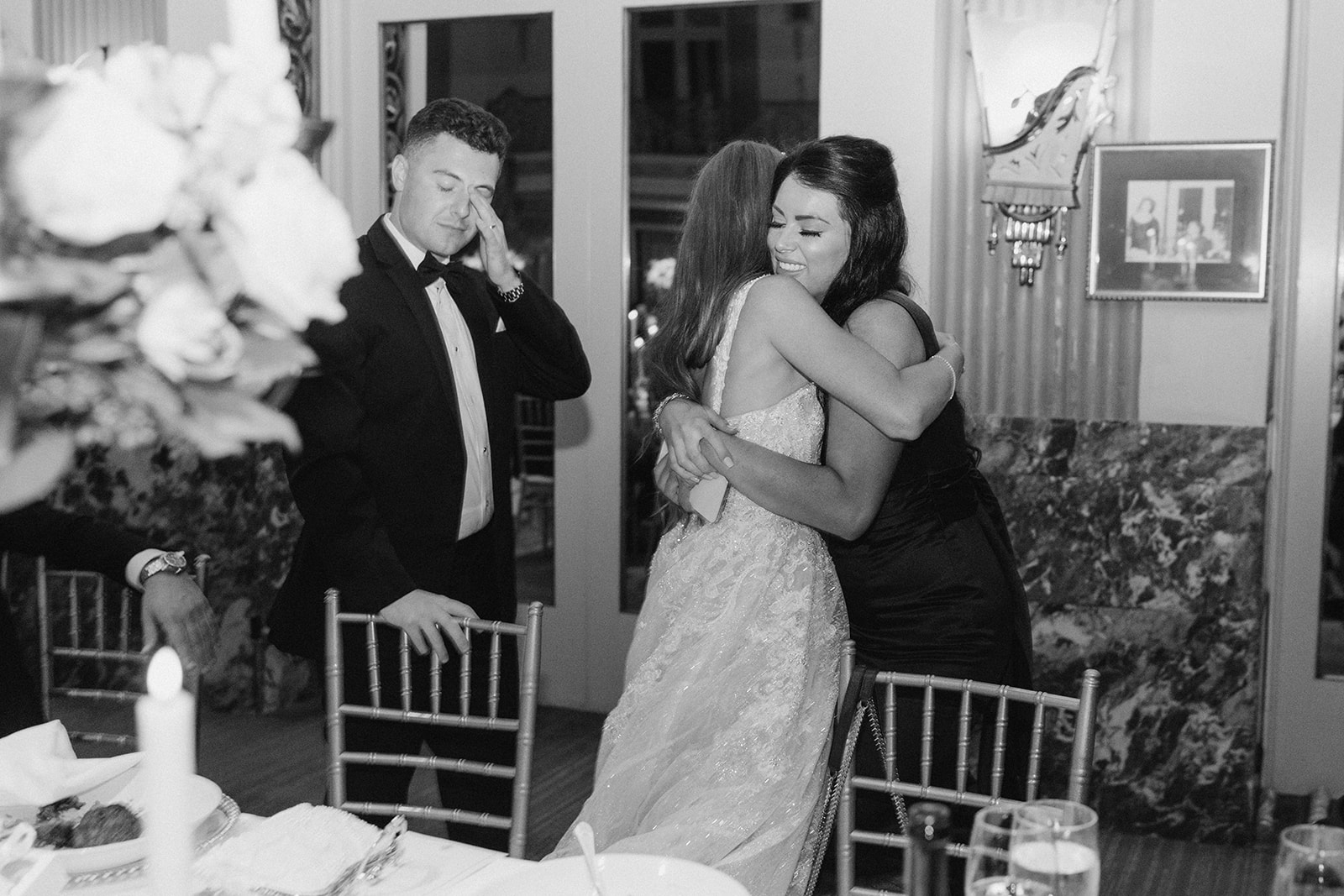 An emotional black-and-white moment during the reception as Dom wipes tears and Hayley embraces a guest