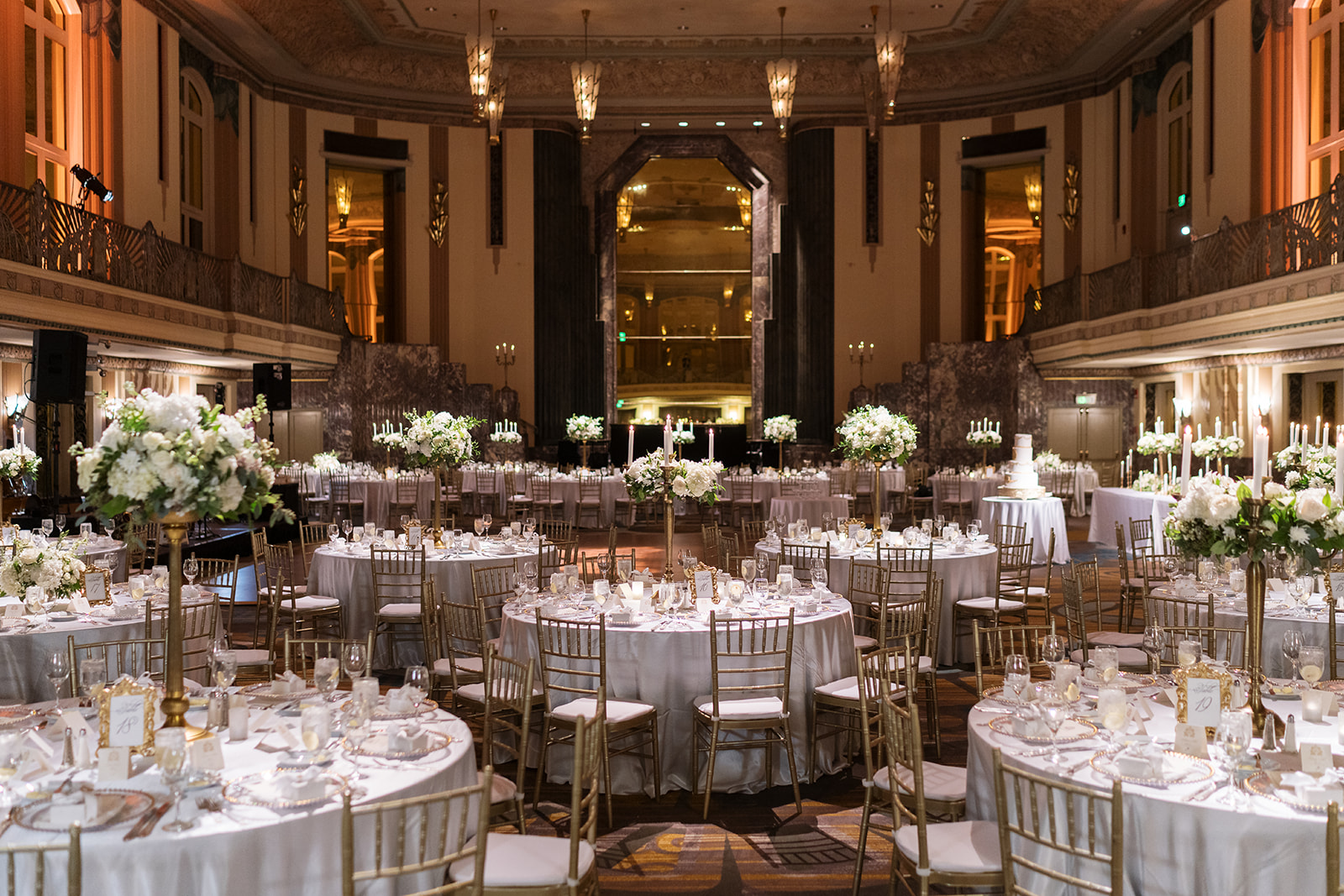 Wide view of the white, green and gold wedding reception inside Hilton Cincinnati Netherland Plaza