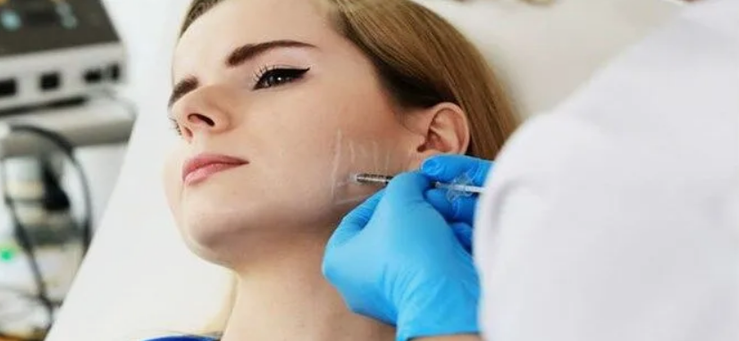 Masseter botoks uygulaması sırasında çene kasına botoks enjeksiyonu yapılan bir birey.