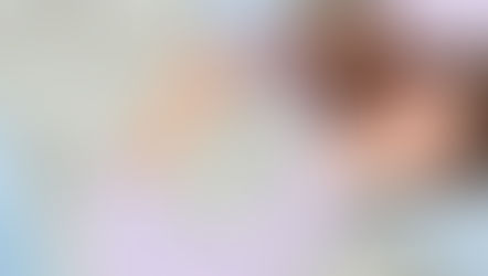 A woman laying in bed smiling with her eyes closed