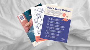 Three flyers about improving sleep lay on a white pillow.