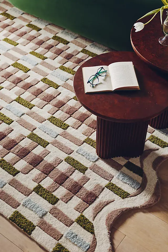 Wavy, scalloped edges and a geometric pattern make this hand-tufted rug a whimsical addition to a bedroom or office.