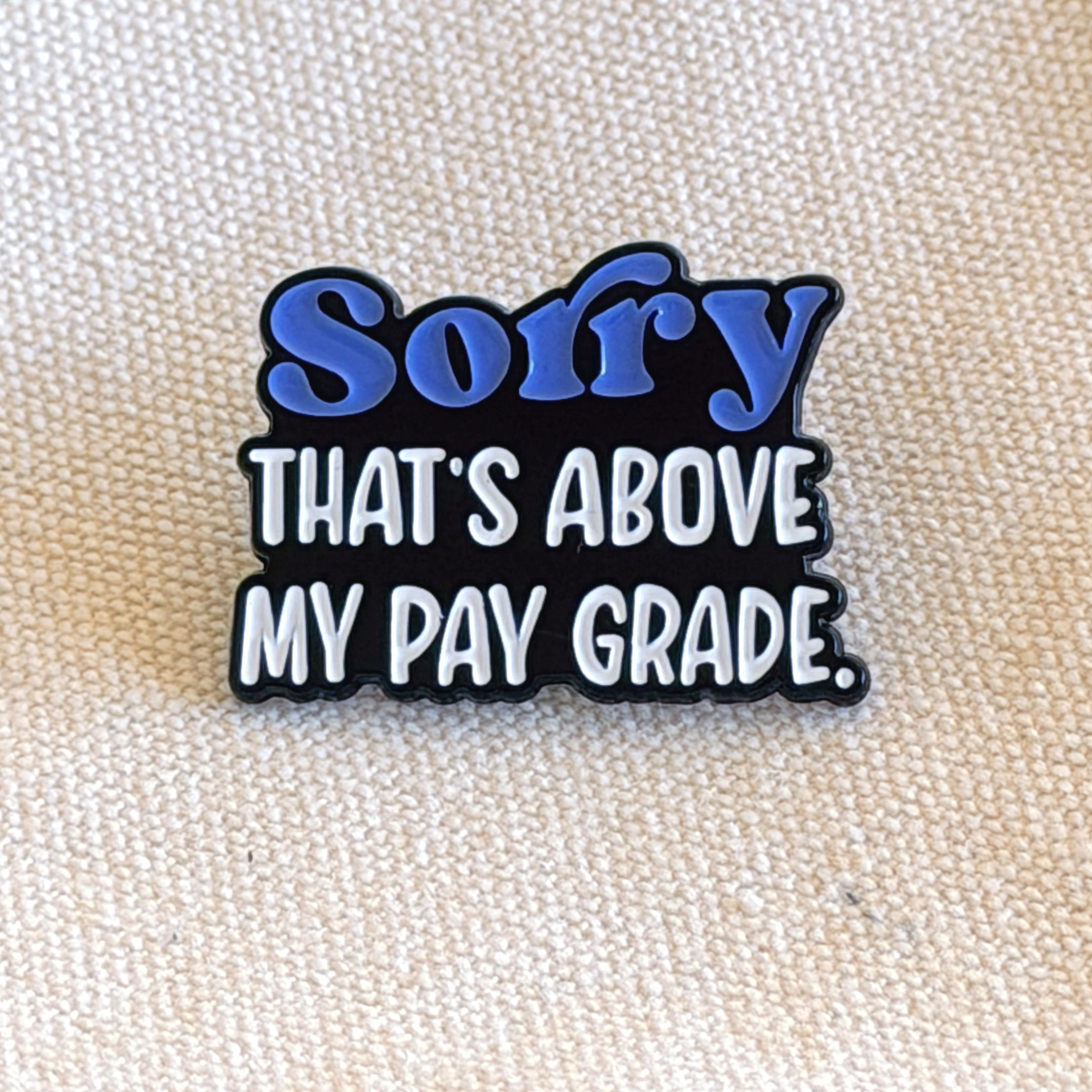 “Sorry That’s Above My Pay Grade” enamel pin.