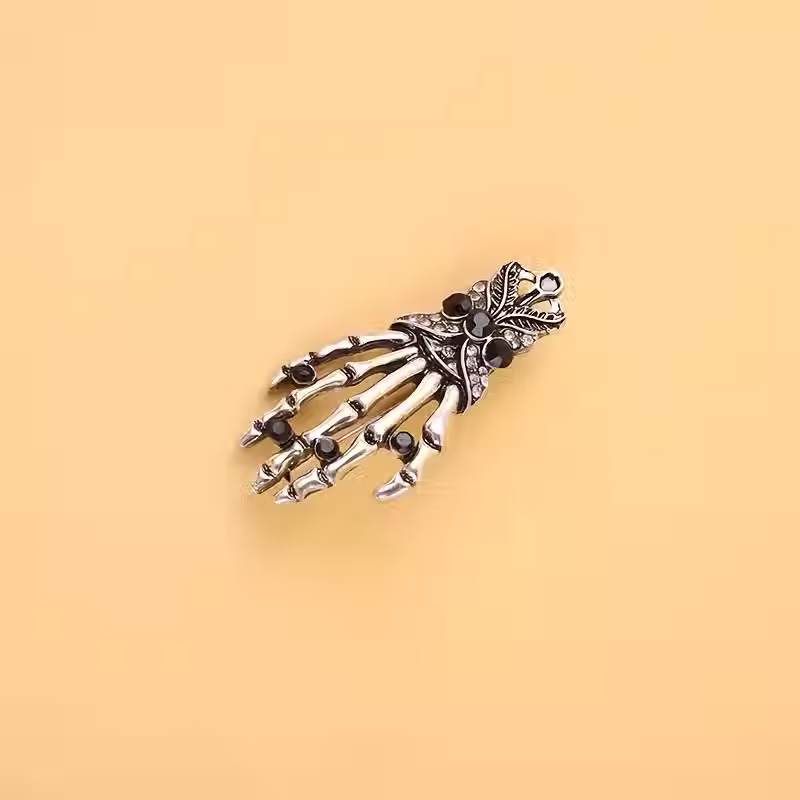 Skeleton Hand Brooch on yellow background